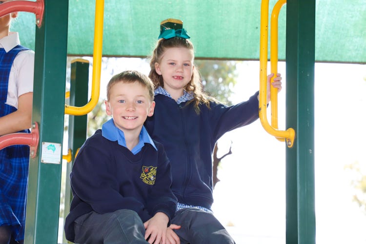 boy and girl sitting on the play equipment
